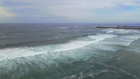 Weiße-Wellen-Rollen--sharpes-Beach-Australien--antenne