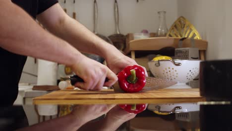 Chef-cuts-big-red-pepper-on-the-cutting-board,-in-the-kitchen