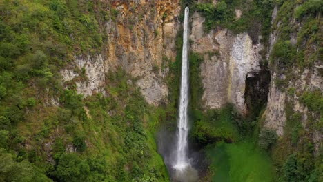 Cinematic-aerial-view-flying-closer-to-the-majestic-Sipiso-Piso-Waterfall-in-North-Sumatra,-Indonesia