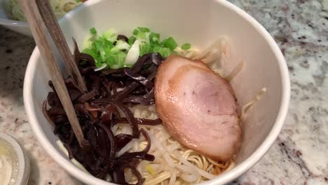 Take-out-Japanese-ramen-noodles-topped-with-sliced-pork-belly,-green-onions,-bean-sprouts,-and-mushrooms