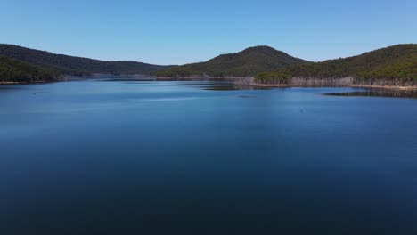 Still-Blue-Water-Of-Advancetown-Lake-With-Forested-Mountain-In-The-Background---Hinze-Dam---Gold-Coast,-QLD,-Australia