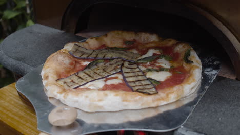 Chef-puts-grilled-eggplants-on-top-of-Neapolitan-pizza-dough-and-rotates-it-on-the-tray