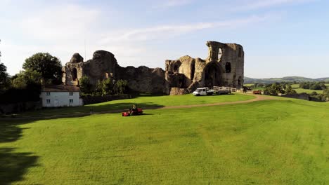 Historic-rural-Welsh-landmark-Denbigh-Castle-medieval-old-hill-monument-ruin-tourist-attraction-aerial-view-rising-forwards