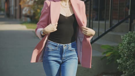 Petite-Woman-With-Her-Tight-Jeans-And-Pink-Suit-Walking-On-The-Sidewalk-During-Daytime