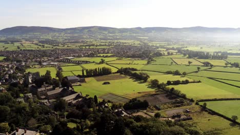 Beautiful-British-North-Wales-patchwork-countryside-rural-misty-farmland-landscape-aerial-view-pull-back-pan-right