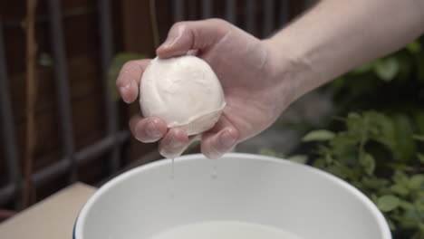 Soaked-mozzarella-cheese,-squeezed-by-hand.-slow-motion