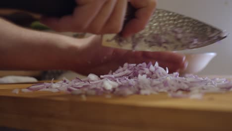 Chopping-onion-with-sharp-knife-on-a-cut-board
