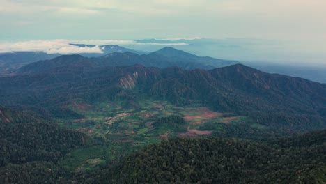Vista-Aérea-Del-Paisaje-Montañoso-Alrededor-Del-Monte-Sibayak-Y-El-Monte-Sinabung-En-El-Norte-De-Sumatra,-Indonesia---Cámara-Inclinándose-Hacia-Arriba