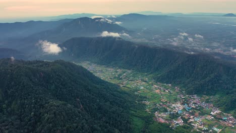 Aerial-view-of-village-in-valley-next-to-Mount-Sibayak-in-North-Sumatra,-Indonesia