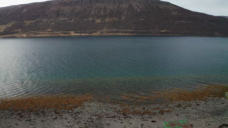 Drone-Vuela-Sobre-Un-Hombre-Nadando-En-Una-Piscina-Geotérmica-En-Westfjords,-Oeste-De-Islandia---Antena
