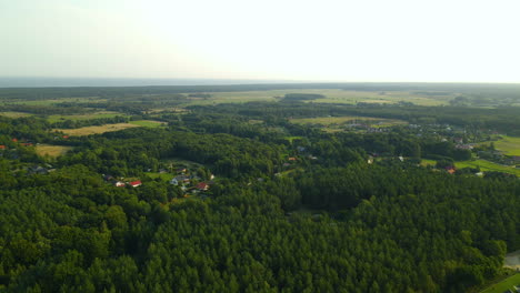 Aerial-view-of-Polish-villages-and-farms-surrounded-by-green-forest-and-farmland