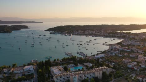 Aerial-drone-bird's-eye-view-video-of-famous-and-picturesque-yacht-dock-seaside-fjord-village-of-Porto-Heli-with-turquoise-and-emerald-clear-waters,-Argolida,-Peloponnese,-Greece