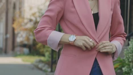 Caucasian-Lady-Wearing-Black-Top-Buttoned-Up-Her-Pink-Jacket-Suit-While-Walking-On-A-Sunny-Day