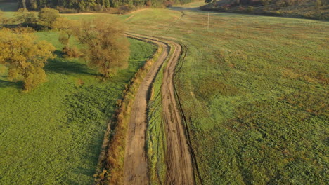 Aerial-view-of-foggy-dirt-road-in-autumn