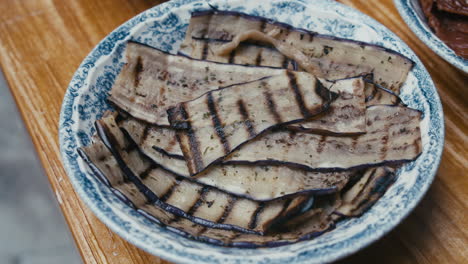Grilled-eggplant-in-a-plate-on-a-wooden-table