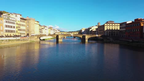 Static-aerial-view-above-Arno-River-and-city-on-a-sunny-day-in-Florence-in-Italy-in-4k