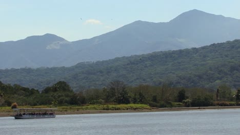 Pequeño-Barco-Fluvial-En-El-Río-Tarcoles-Y-El-Hermoso-Paisaje-Circundante-En-Costa-Rica
