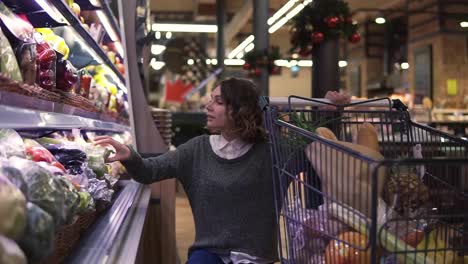 Young-woman-in-modern-supermarket-choosing-celery-leek-in-organic-vegetable-department.-Healthy-female-buying-green-food.-Concept-fresh,-assortment,-vegetarian-girl-in-grocery-store