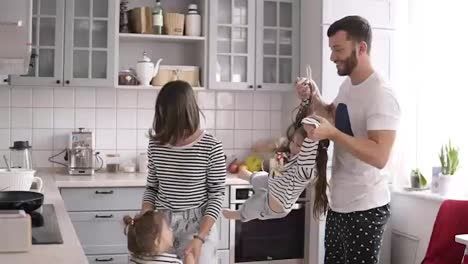 Young-family-with-two-children-are-dancing-and-have-fun-on-the-kitchen.