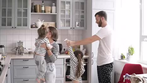 Junge-Familie-Mit-Zwei-Töchtern-Tanzt-In-Der-Küche