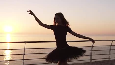 A-ballerina-practicing-a-ballet-dance-near-the-sea.-Preparing-and-doing-a-jump.-Wondeful-sunlight-on-the-backstage.-Slow-motion