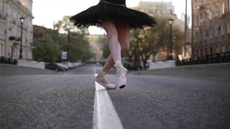 Elegant-young-ballet-dancer-on-the-street-on-an-empty-road.-Stepping-on-tip-toes-in-pointe.-Close-up-of-a-ballerina's-legs.-Slow-motion