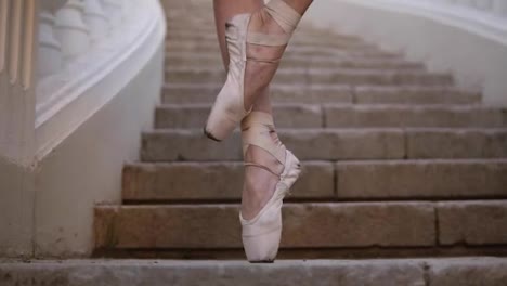 Close-up-of-a-woman's-feet-in-beige-pointe.-Young,-beautiful-ballerina-demonstrating-ballet-movements.-Black-tutu.-Upward-footage