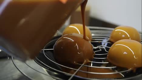 Process-of-creating-delicious-dessserts.-Covering-baked-cakes-with-glazing.-Second-layer-of-caramel-on-top.-Close-up-footage.