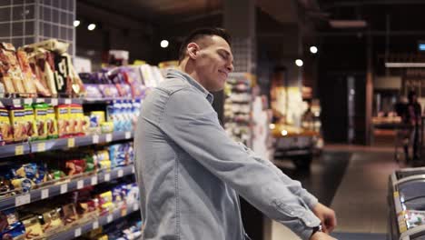 Man-in-supermarket-dancing-with-shopping-trolley.-Positive-dances-in-an-empty-food-store
