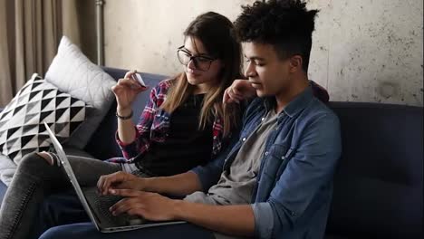 Young-happy-couple-of-two-hipsters-ordering-food-online,-using-laptop