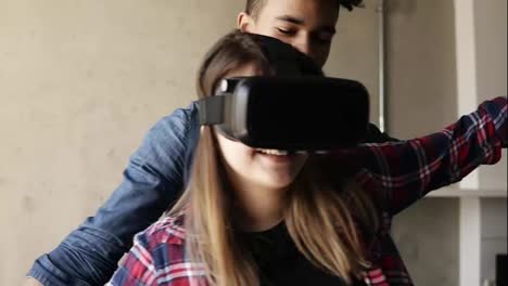 Cute-happy-couple,-girl-is-experiencing-virtual-reality-game,-with-her-boyfriend-guiding-her.