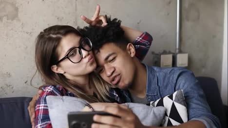 Cute-happy-couple-taking-selfies-on-the-couch.