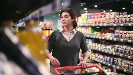 Young-beautiful-female-costumer-choosing-oil-in-local-grocery-store.