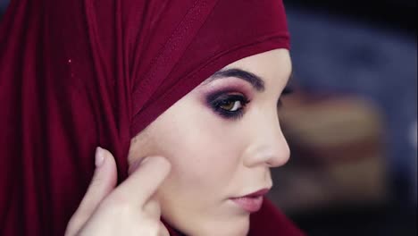 Unglaublich-Schönes-Mädchen-Mit-Haselnussbraunen-Augen-Und-Lila-Hijab-Auf-Dem-Kopf-Passt-Ihre-Traditionelle-Arabische-Kopfbedeckung-An,-Während-Sie-Ihr-Makelloses-Make-up-überprüft