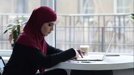Attraktives-Junges-Muslimisches-Mädchen-Mit-Hijab-Nutzt-Laptop,-Um-Wichtige-Informationen-Zu-Finden