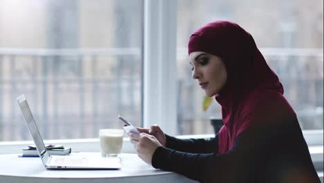 Innenaufnahmen-Eines-Attraktiven-Muslimischen-Mädchens,-Das-Verschiedene-Geräte-Wie-Smartphone-Und-Laptop-Benutzt