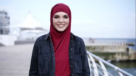 Frontside-footage-of-an-attractive-young-muslim-girl-with-stunning-colorful-smokey-eye-make-up-looking-right-at-the-camera-while-walking-near-the-sea-side