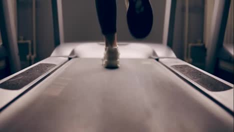 Female-legs-running-on-treadmill-slowmotion,-indoors-footage.
