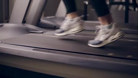 Slow-motion-footage-of-female-legs-in-fancy-sneakers-running-on-treadmill.