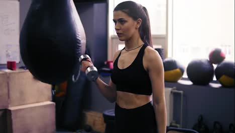 Young-attractive-girl-with-athletic-body-working-out-with-dumbbells,-breathing-intensly.