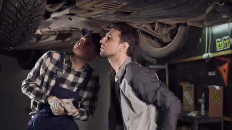 Mechanic-and-his-male-client-checking-out-the-repaired-veicle.-Customer-shakes-hands-with-auto-repair-service-represantative.