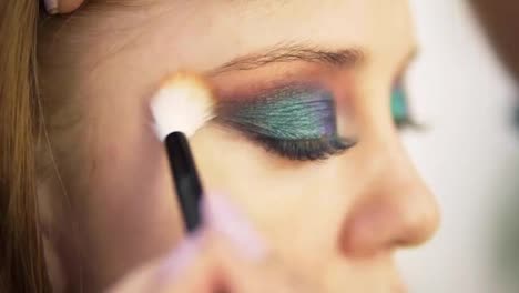 Eye-makeup-woman-spreads-the-eyeshadow-with-brush.-Beautiful-woman-face.-Perfect-colourful-makeup.-Close-up.-Side-view