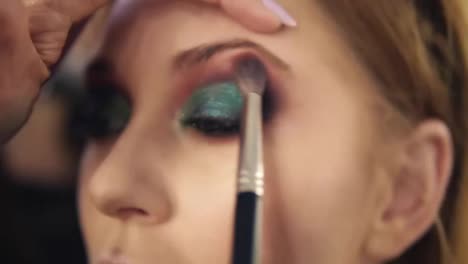 Finishing-eyes-make-up-for-a-young-woman.-Green-colour.-Close-view