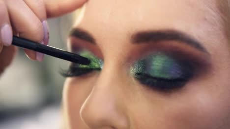 Extremely-close-applying-shine-bright-green-shadows-on-eye-corner.-Beautiful-caucasian-model