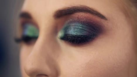 Seductive-young-woman-with-green-eyes.-Slowly-open-her-eyes.-Professional-smoky-eyes-makeup.-Close-up