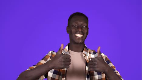 Fröhlicher,-Lächelnder-Afroamerikanischer-Mann-In-Guter-Laune-Auf-Blauem-Hintergrund.-Gestikulieren-Mit-Erhobenem-Daumen,-Wie-Eine-Geste-–-Menschliche-Emotionen