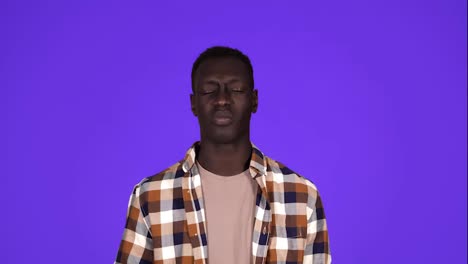 Portrait-of-sick-african-american-man-in-plaid-shirt-touching-jawbone-with-pain-on-face-and-suffering-from-dental-problem,-isolated-over-blue-background.-Concept-of-emotions