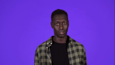 Younf-African-American-man-feeling-fear-isolated-on-blue-background.-Covers-his-face-with-hands-in-a-fear,-scary-of-something