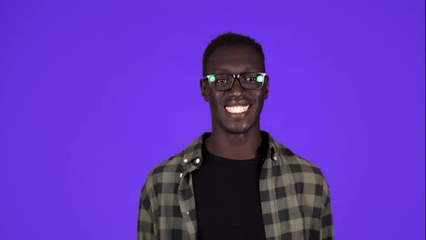 Happy,-confident-afro-american-man-in-casual-clothes-and-stylish-glasses-looking-at-camera-in-wide-toothy-smile-isolated-on-the-blue-background