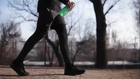 Male-legs-in-black-tight-compression-leggins-walking-in-park.-Sport-and-recreation.